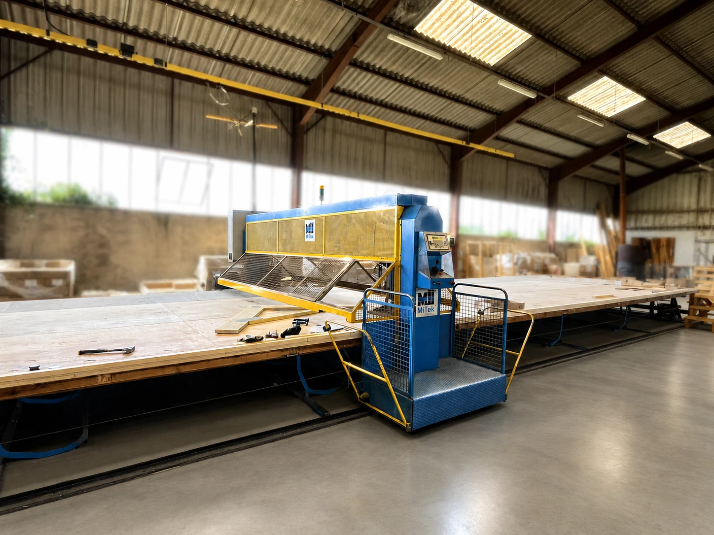 Presse MiTek pour fermettes industrielles — atelier DUSOGAT Construction